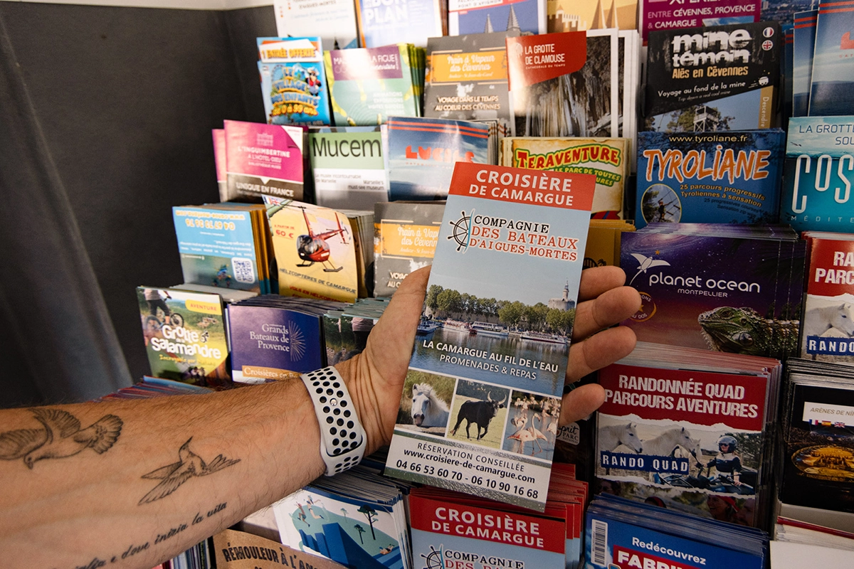 portant de dépliants d'activités à faire autour de Mon Auberge à Lunel