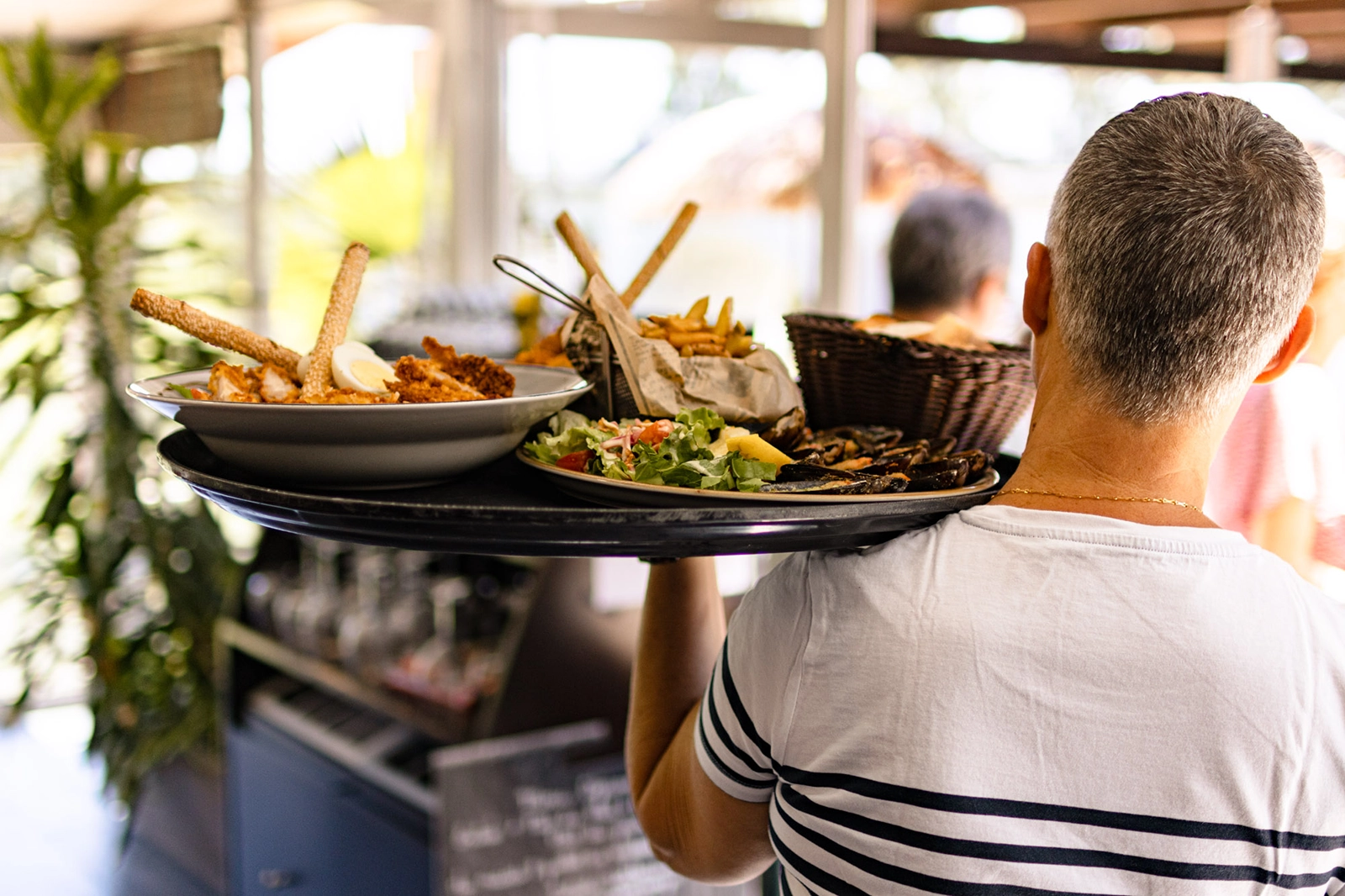 Serveur du restaurant Mon Auberge apportant des plats